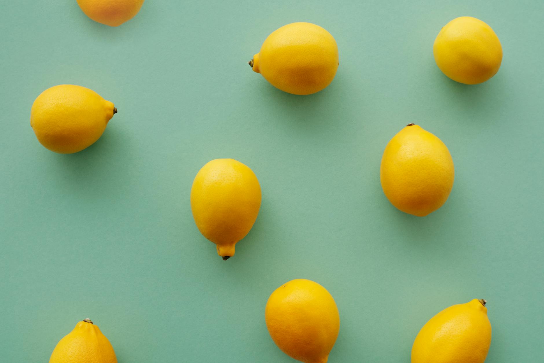 Fresh bright yellow lemons on a soft green background, representing the refreshing intensity of lemon vibrators