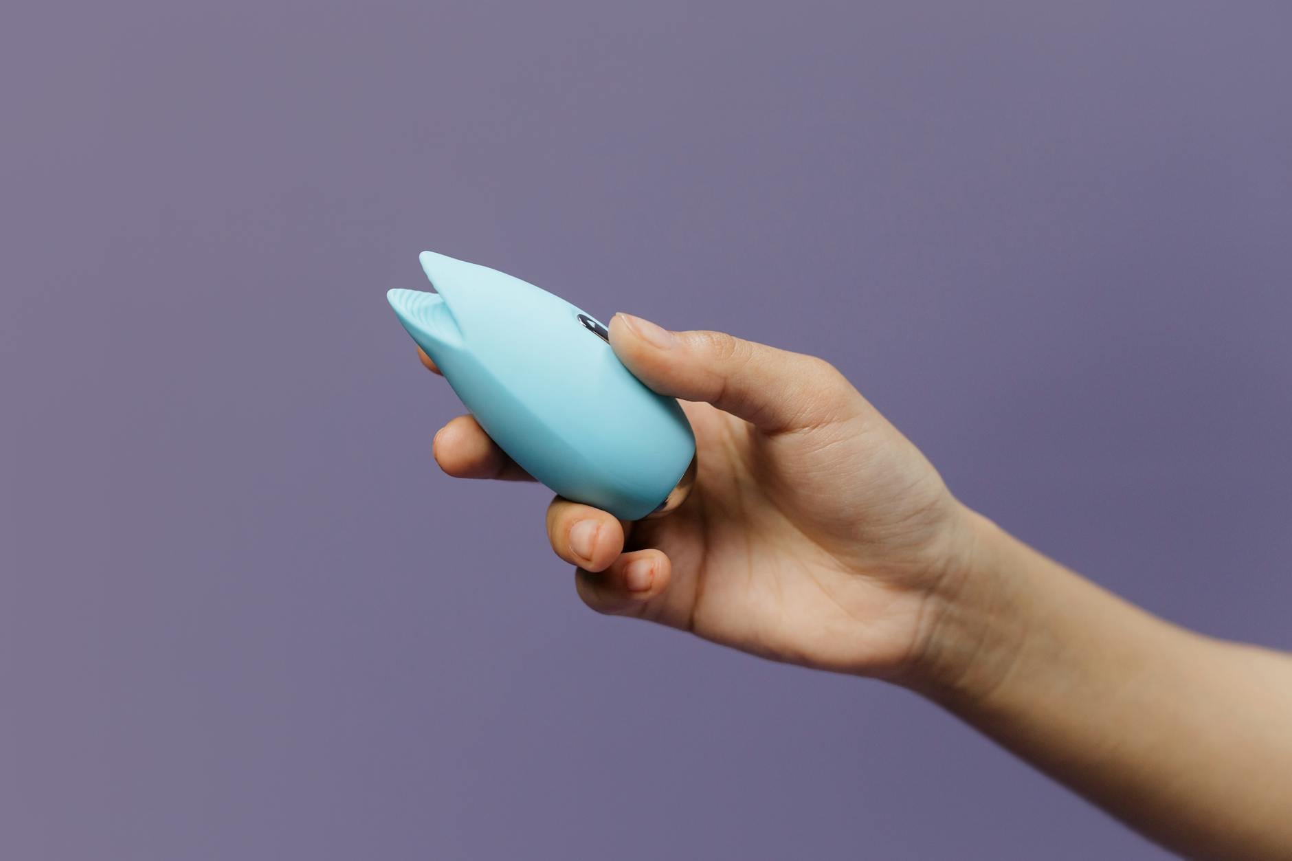 A blue silicone lemon vibrator held in hand, symbolizing personal pleasure and intimate connection