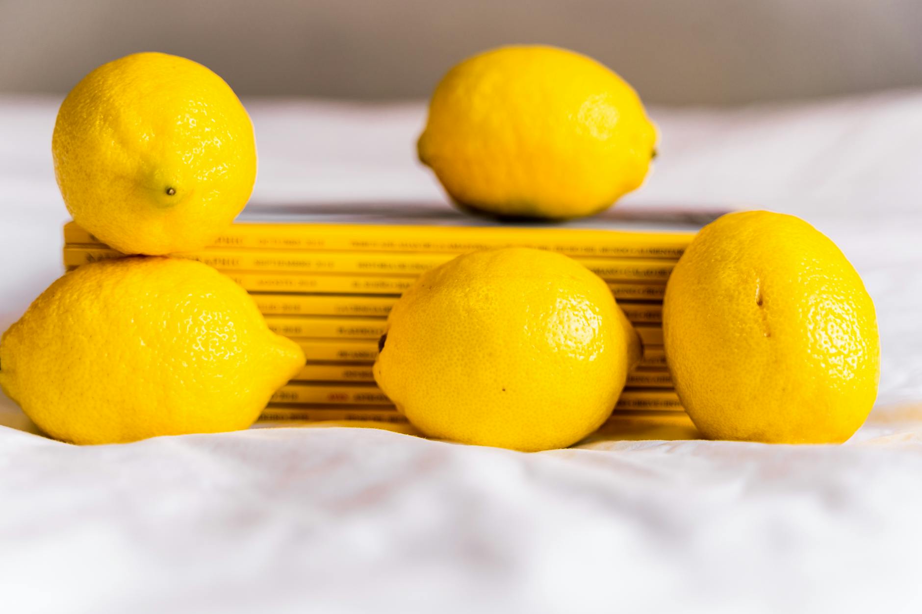 Hand holding a lemon against bright yellow background, fresh and vibrant